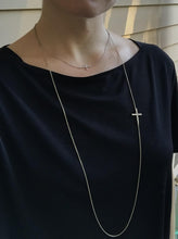 Sideways cross close to neck line shown with asymmetrical cross